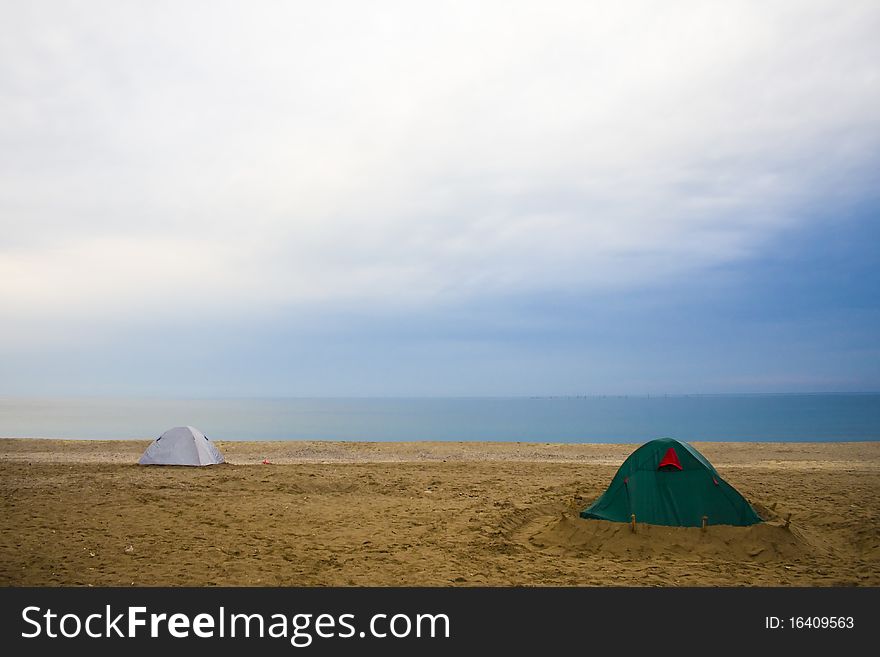 A beach scene with accumulated clouds and two tents. A beach scene with accumulated clouds and two tents