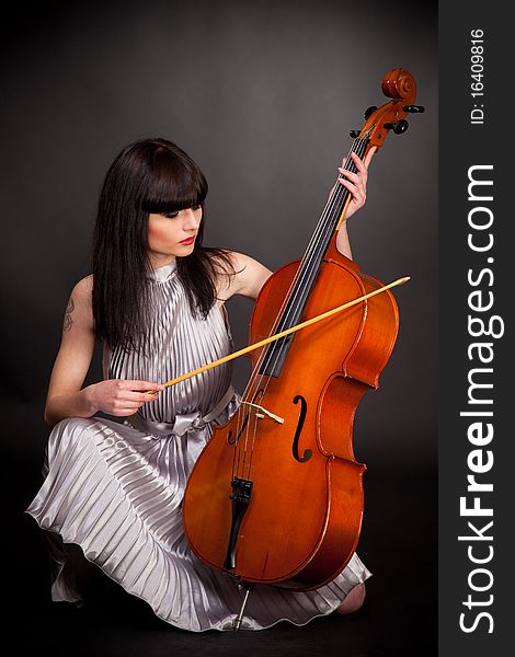 Girl with cello, studio isolated shot