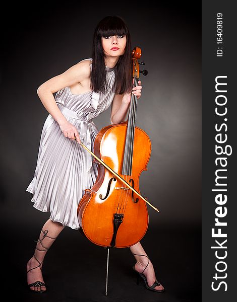 Brunette girl with cello, close up studio isolated shot
