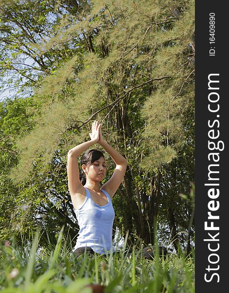 An Asian woman doing some yoga exercise at a forest. An Asian woman doing some yoga exercise at a forest