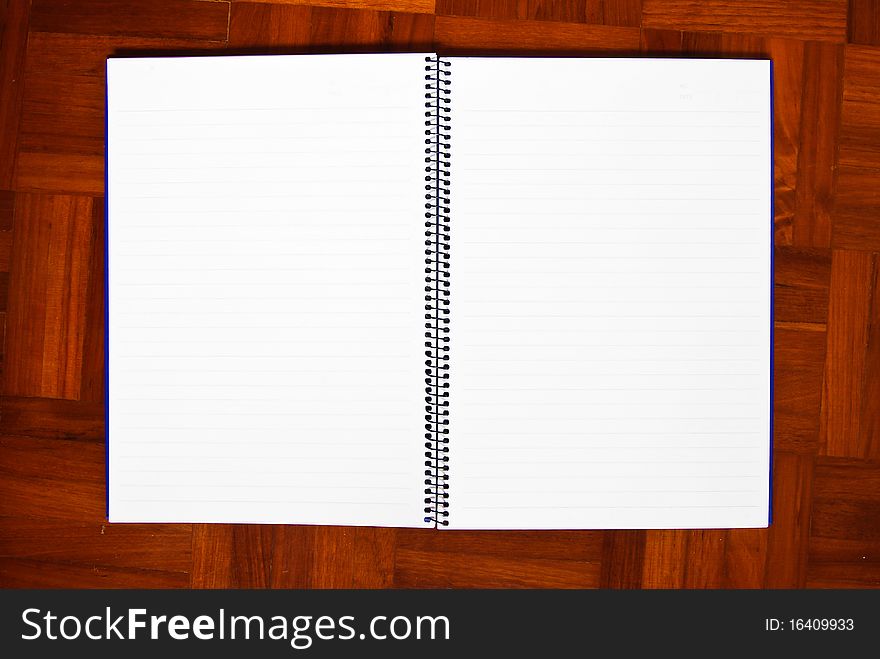 Blank notebook on the parquet background