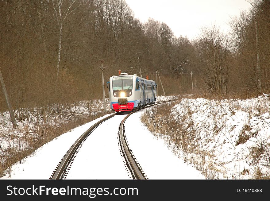 Railcar traveling by rail through the forest in winter. Railcar traveling by rail through the forest in winter