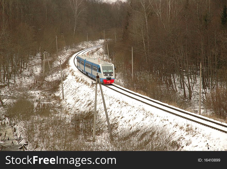 Railcar traveling by rail through the forest in winter. Railcar traveling by rail through the forest in winter
