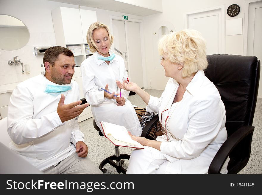 Three doctors talking.Focus on the middle doctor