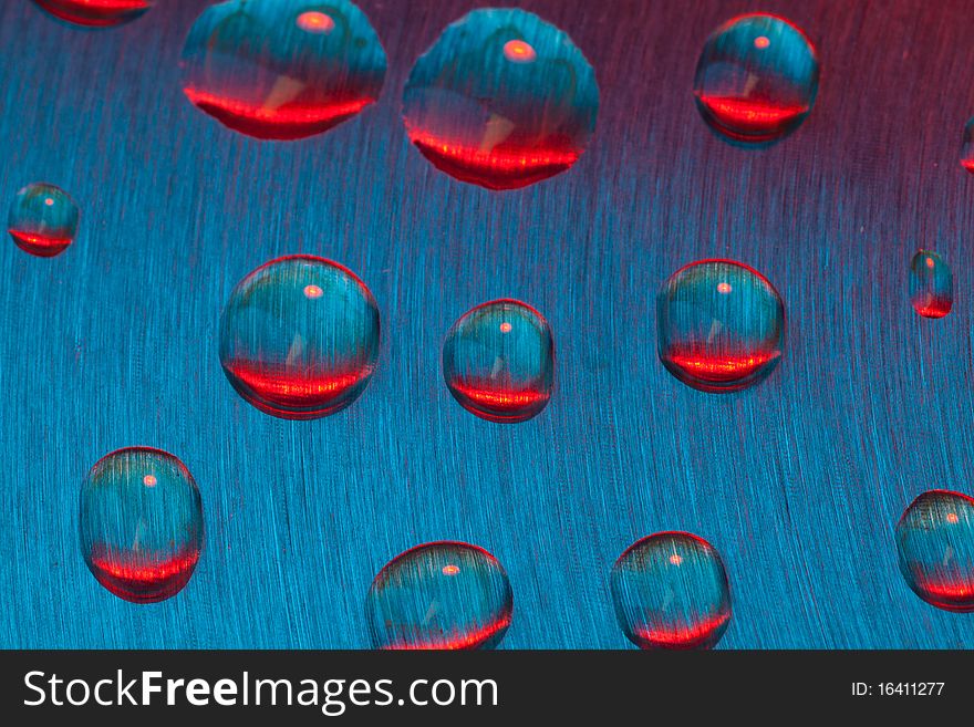 Color drops of water on textured metal. Color drops of water on textured metal