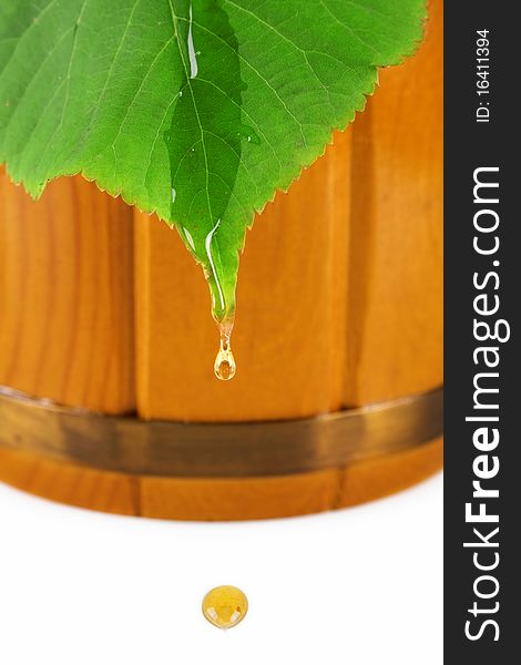 Wooden barrel, drop of honey and leaf linden