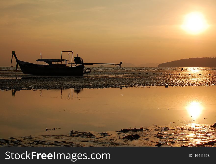 Evening low tide in Thailand, Krabi. Fisherman boat. Sunset.