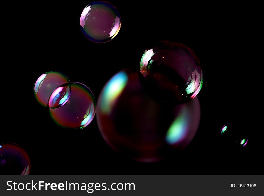 Seven soap bubbles isolated on black