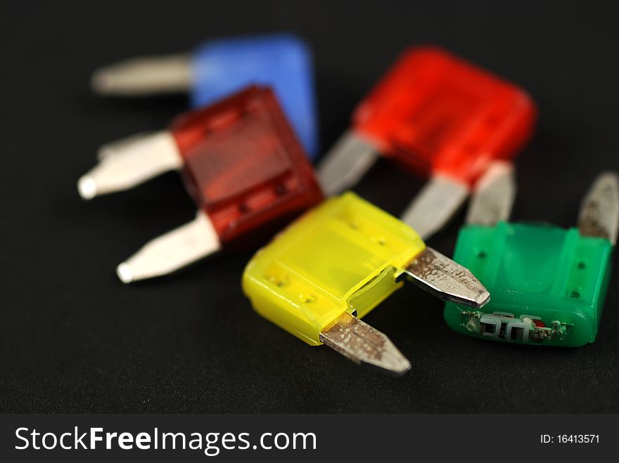 Electrical automobile fuses with shallow depth of field on black background