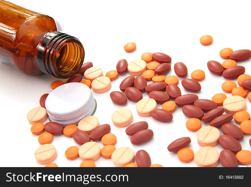 Closeup of Open pill bottle with medicine spilling out of it isolated on white. Closeup of Open pill bottle with medicine spilling out of it isolated on white