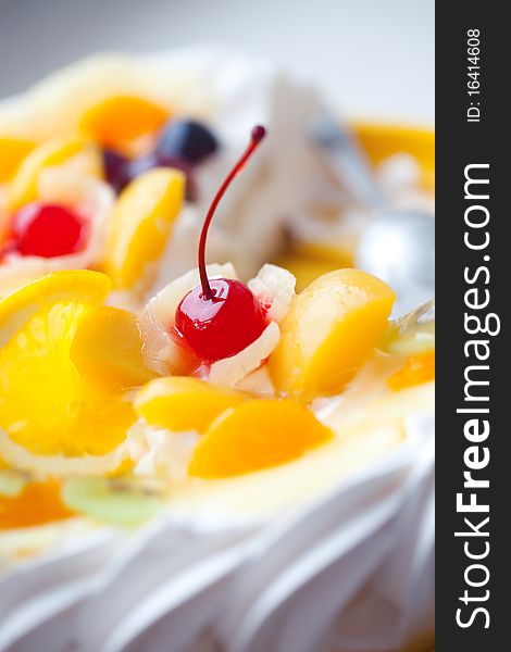 Pie decorated with fruit and a cherry, close up