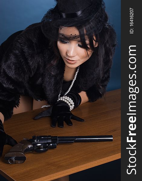 Elegant lady with a pistol in hands