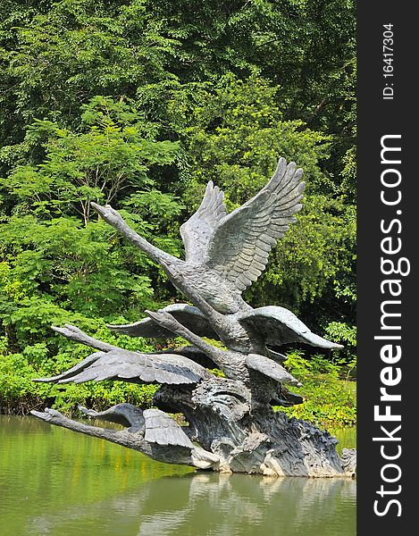 Metal swan sculptures in lake showing swans in states of flight.