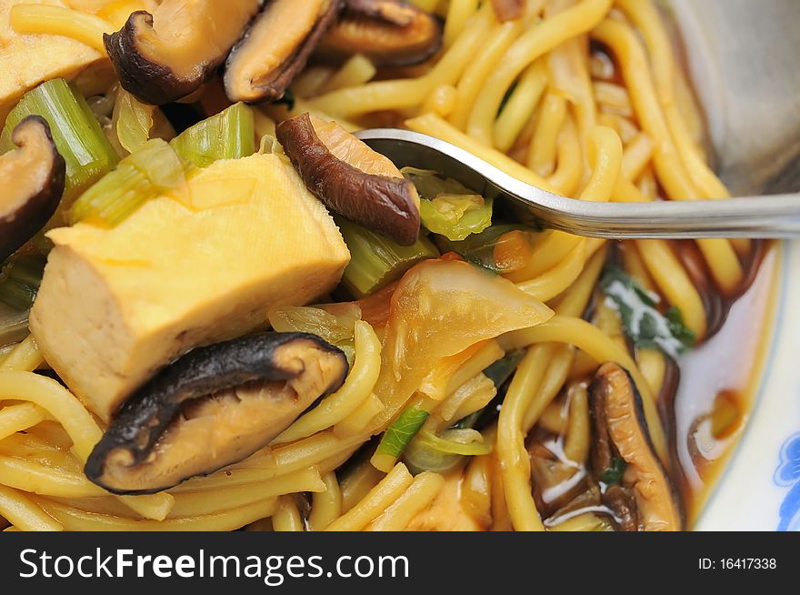 Eating Oriental style soup noodles with fork. Eating Oriental style soup noodles with fork.