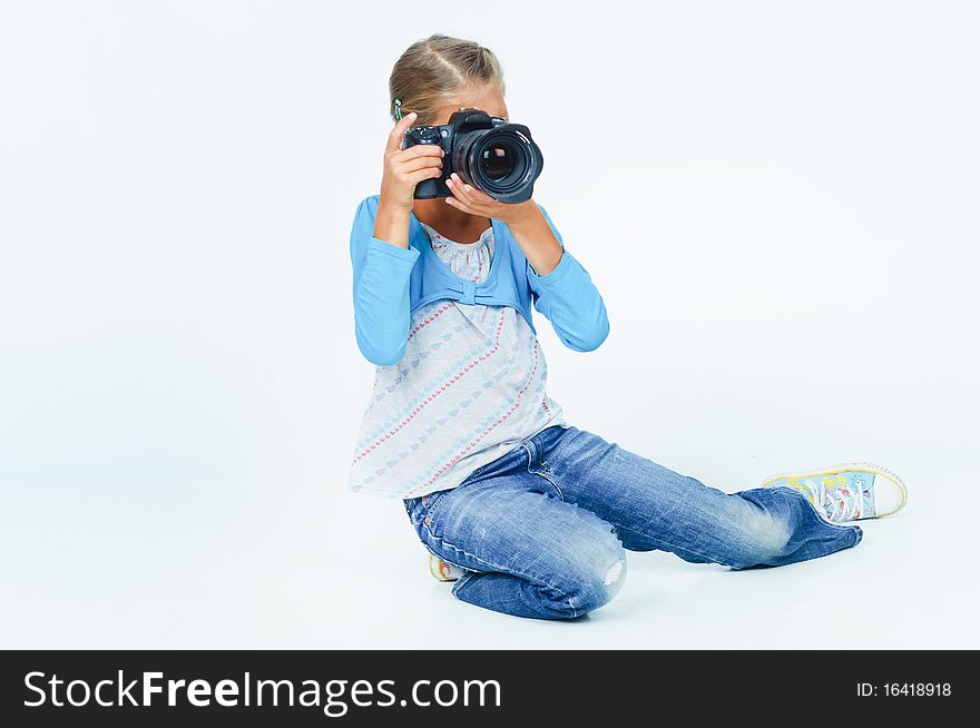 Pretty lovely girl with a camera big lens. In the studio