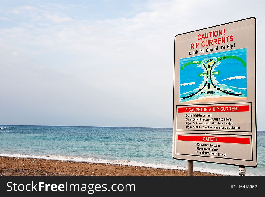 Warning sign for dangerous waters , rip currents,  advising the swimmers to be careful when swimming. Warning sign for dangerous waters , rip currents,  advising the swimmers to be careful when swimming