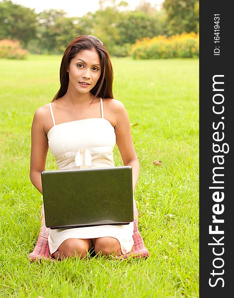 Outdoor portrait of a lovely young woman with laptop