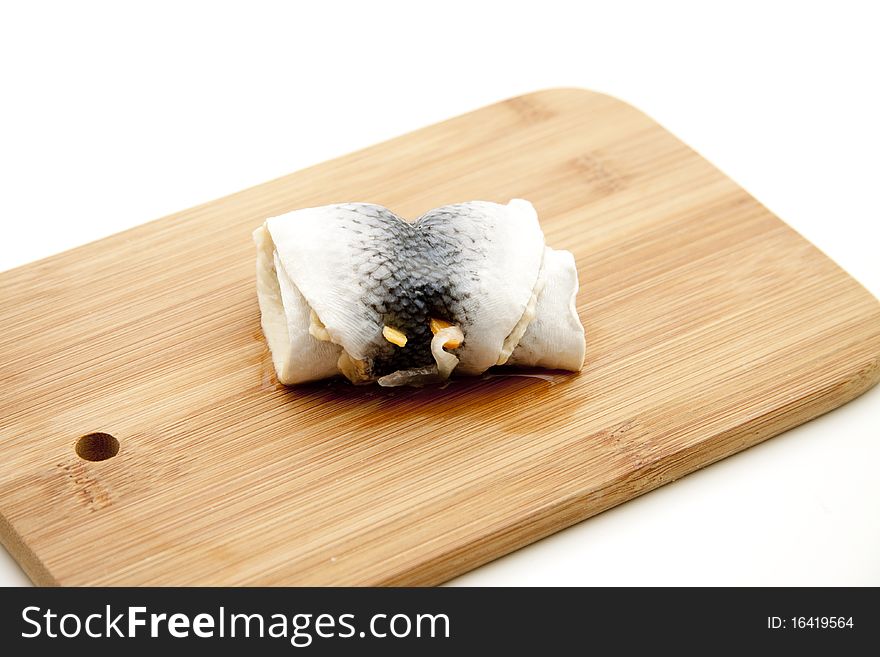 Rolled pickled herring and on edge board