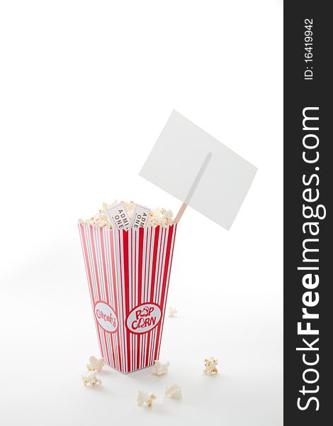 A carton of popcorn, a reel of tickets and a sign. A carton of popcorn, a reel of tickets and a sign