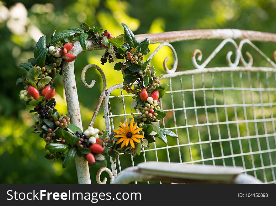 Autumn wreath with flowers and berries on a old garden bench. Autumn wreath with flowers and berries on a old garden bench