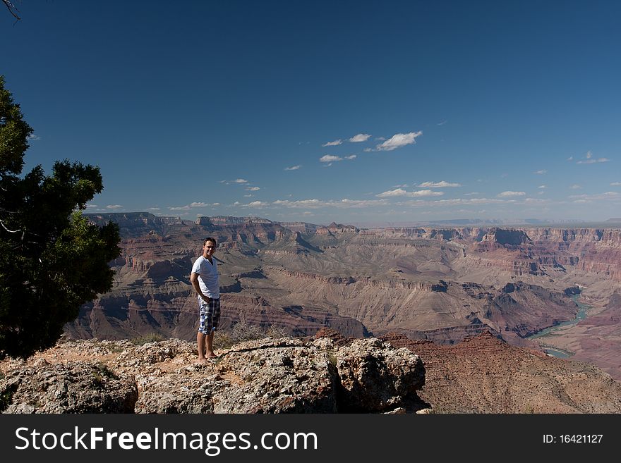 A man posing on top of a mountain at the canyons in USA. A man posing on top of a mountain at the canyons in USA