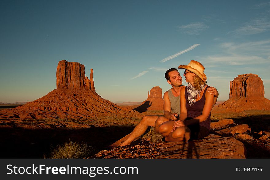 A portrait of a love couple posing in front of a rock found in monument valley utah. A portrait of a love couple posing in front of a rock found in monument valley utah