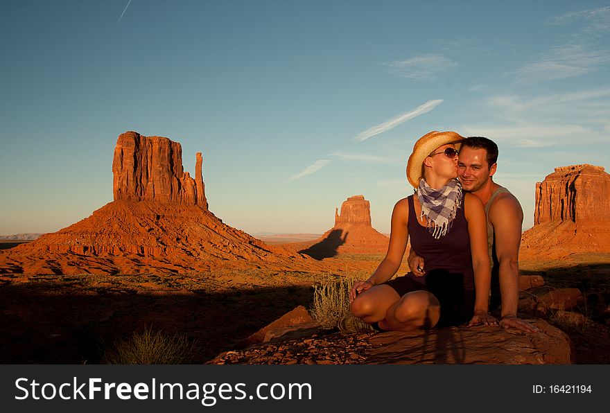 A portrait of a woman kissing her man in front of a rock found in monument valley utah. A portrait of a woman kissing her man in front of a rock found in monument valley utah