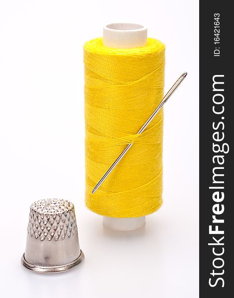 Spool of thread for sewing with needle and thimble