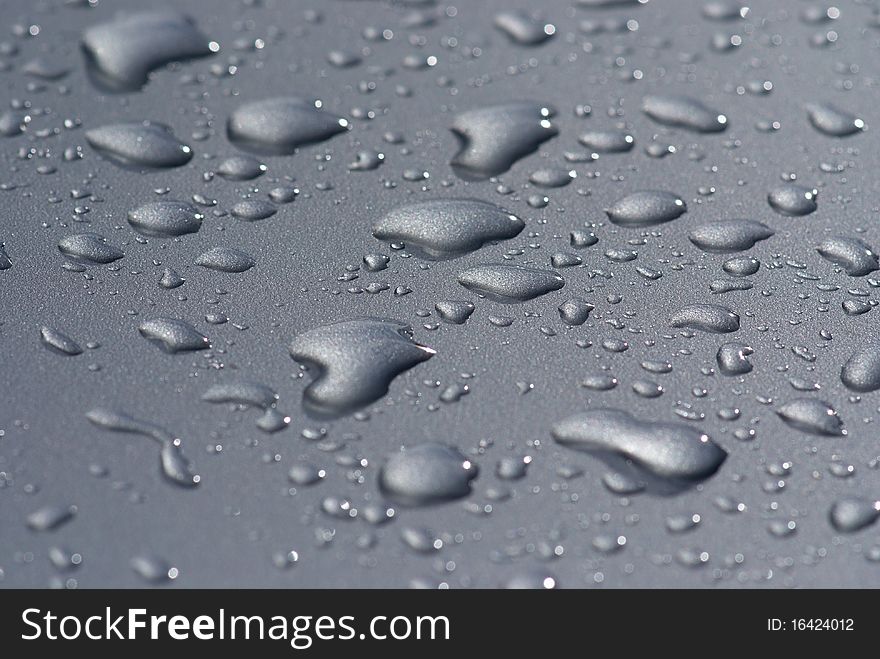 Raindrops on the hood of a gray car. Raindrops on the hood of a gray car