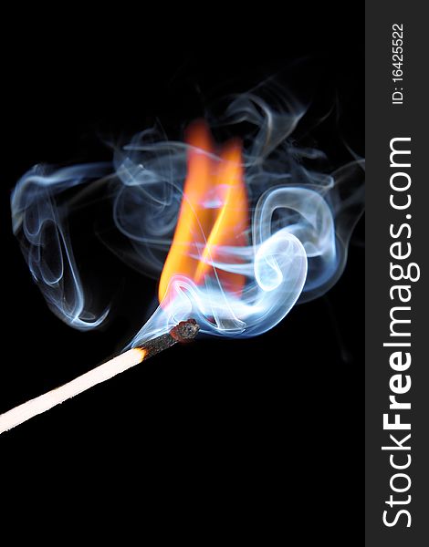 Burning match in smoke, close-up, not isolated