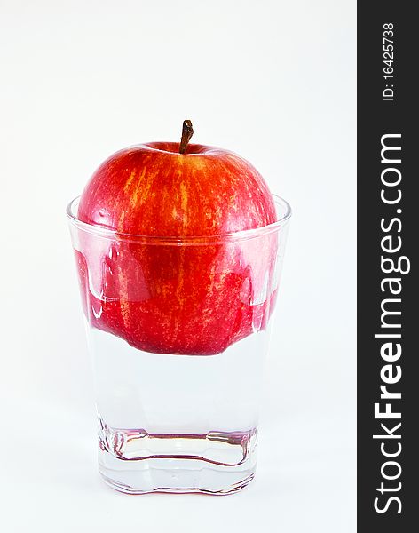 Apple in a glass of water isolated