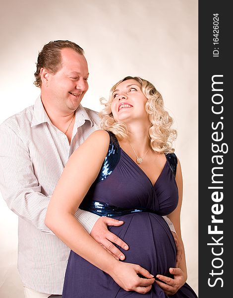 Photo of falling in love of man and woman is in a studio. A woman is pregnant. Photo of falling in love of man and woman is in a studio. A woman is pregnant.