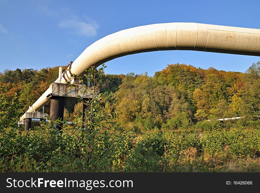 The high pressure pipeline in an autumn landscape with the dark blue sky. The high pressure pipeline in an autumn landscape with the dark blue sky