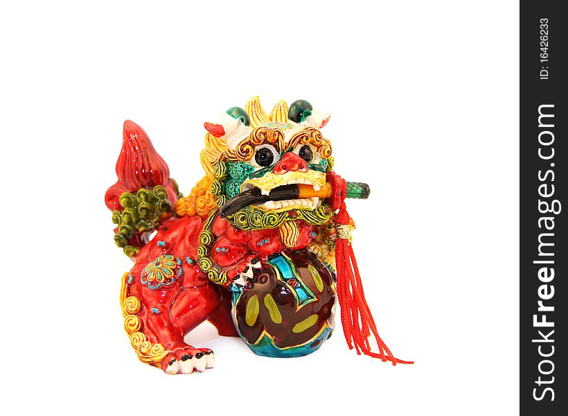 Multi-colored mystical Asian lion with a dagger in a mouth and a sphere in paws. Multi-colored mystical Asian lion with a dagger in a mouth and a sphere in paws