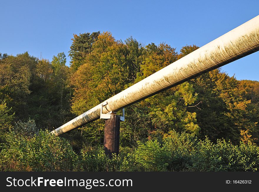 The high pressure pipeline in an autumn landscape with the dark blue sky. The high pressure pipeline in an autumn landscape with the dark blue sky