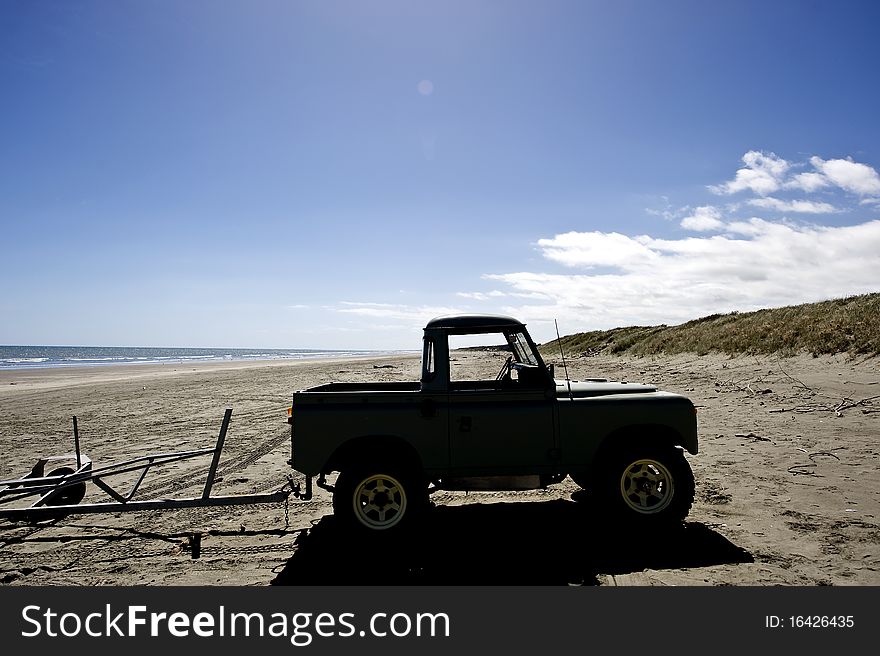 Silhouette of a four wheel drive on a deserted West Coast New Zealand beach. Silhouette of a four wheel drive on a deserted West Coast New Zealand beach