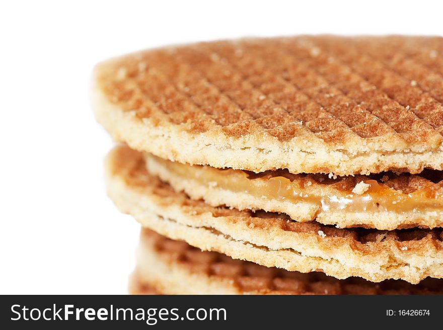 A stack of golden round waffles with caramel isolated over white background.