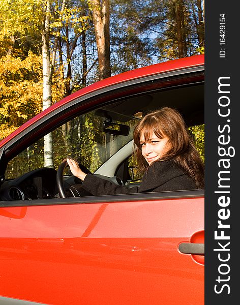 The girl in the red car in autumn