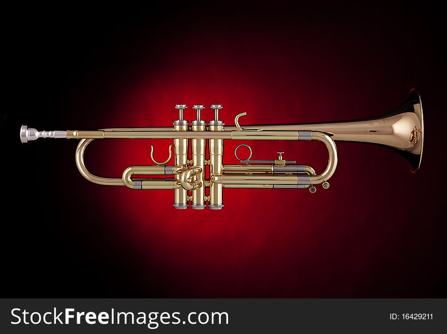 A professional gold trumpet isolated against a spotlight red background. A professional gold trumpet isolated against a spotlight red background.
