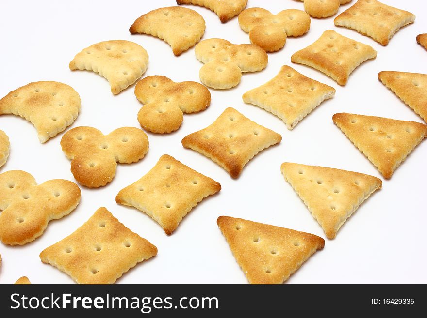 Salty crackers of the various geometrical form lie on a white background. Salty crackers of the various geometrical form lie on a white background