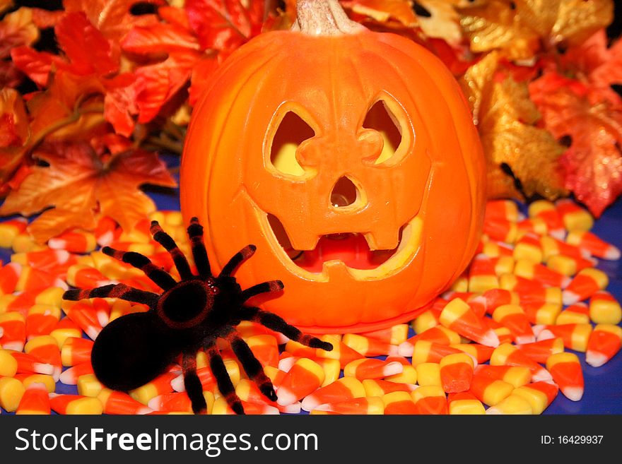 Jack o Lantern, with candy corn for halloween and a spider crawling around. Jack o Lantern, with candy corn for halloween and a spider crawling around