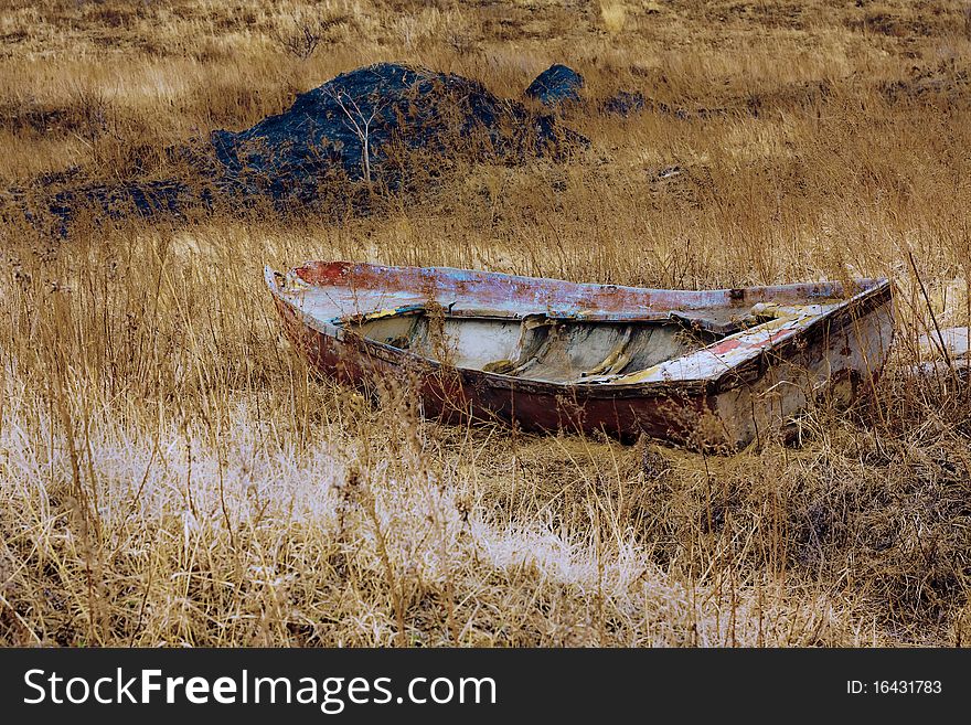 The thrown boat costs in a yellow grass