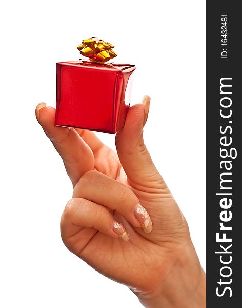 Woman's hand with a small red gift box with gold bow isolated on white background