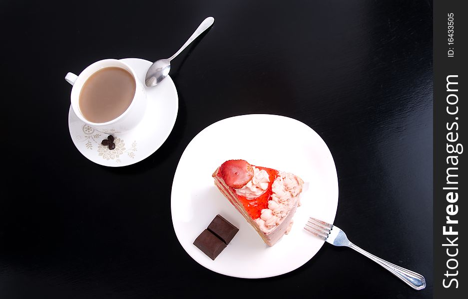 Strawberry cake dessert with cup of cafe on black background. Strawberry cake dessert with cup of cafe on black background