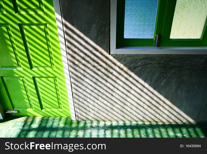 The graphic of highlight and shadow on green door.