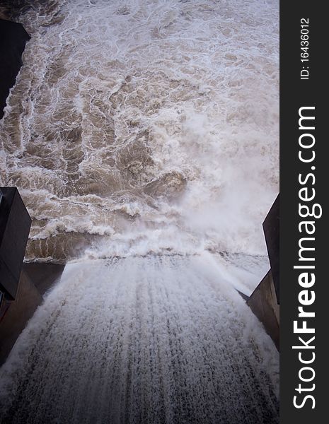 Looking down the spillway of a dam as water spills over. Focus on the water below. Looking down the spillway of a dam as water spills over. Focus on the water below.