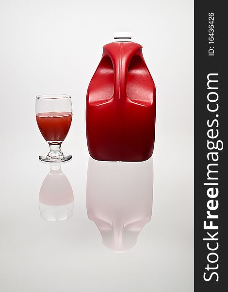 A reflection of a red punch bottle and glass of juice. A reflection of a red punch bottle and glass of juice.
