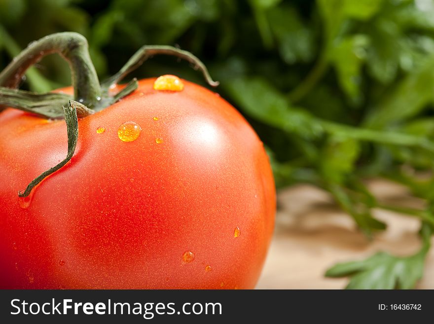 Fresh tomatos tomatoes on a bamboo cutting board with italian parsely in the background. Fresh tomatos tomatoes on a bamboo cutting board with italian parsely in the background