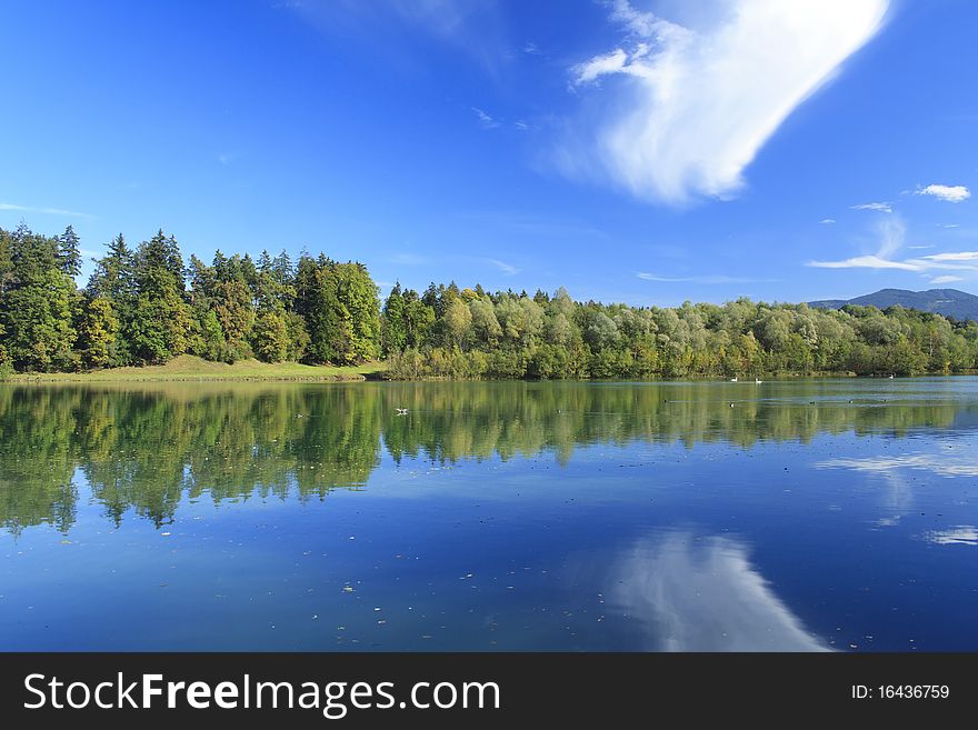 Blue lake with colorful wood and blue sky in autumn. Blue lake with colorful wood and blue sky in autumn