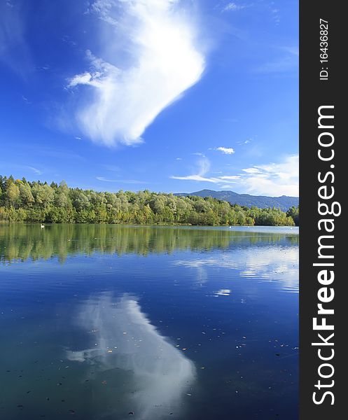 Blue lake with colorful wood and blue sky in autumn. Blue lake with colorful wood and blue sky in autumn